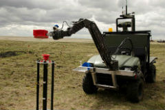 The MATS vehicle, equipped with robotic arm, handles a highly radioactive material used for a trial at DRDC – Suffield Research Centre. The MATS system allows the operator to stay a safe distance away during manipulation of the source.