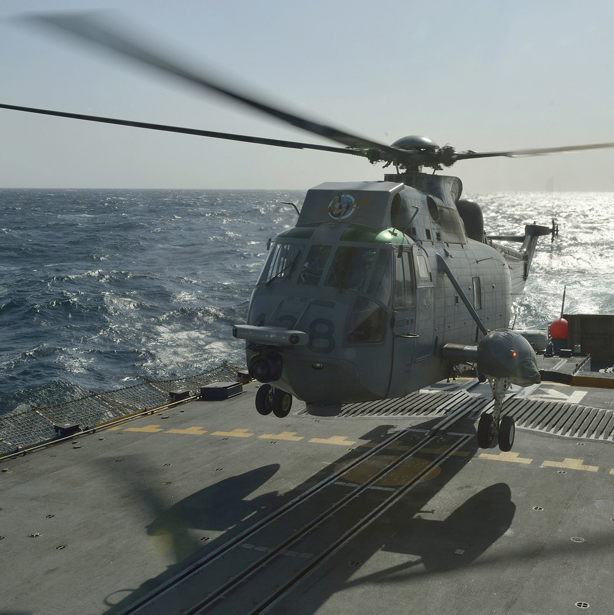 A Sea King helicopter lands on the flight deck of a Royal Canadian Navy ship.