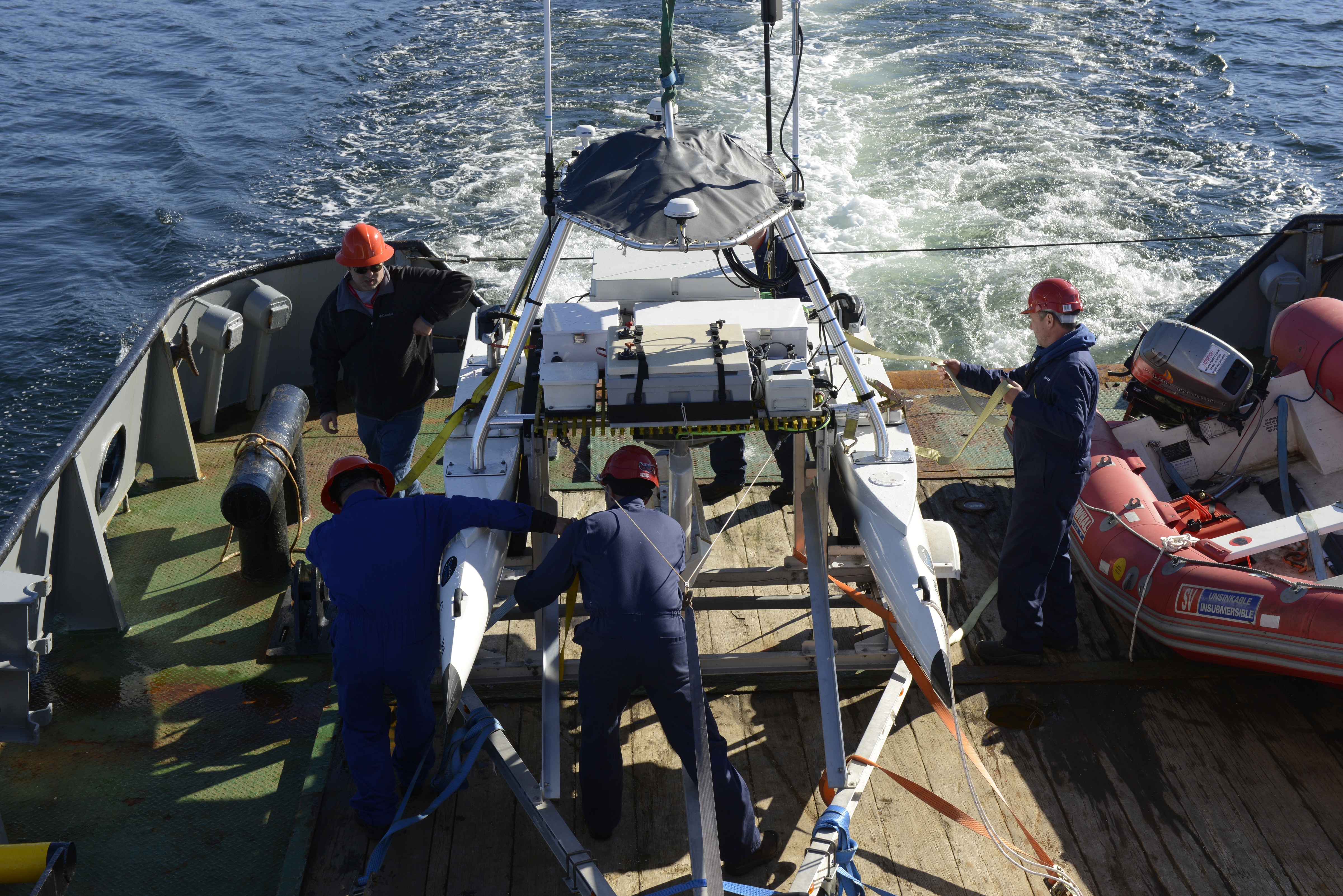 Defence Research and Development Canada technologists and ship crew secure their USV-2600 unmanned surface vehicle on the SD Kyle of Lochalsh ship after completing a mission in Belmacara Bay. Photo by Janice Lang, DRDC