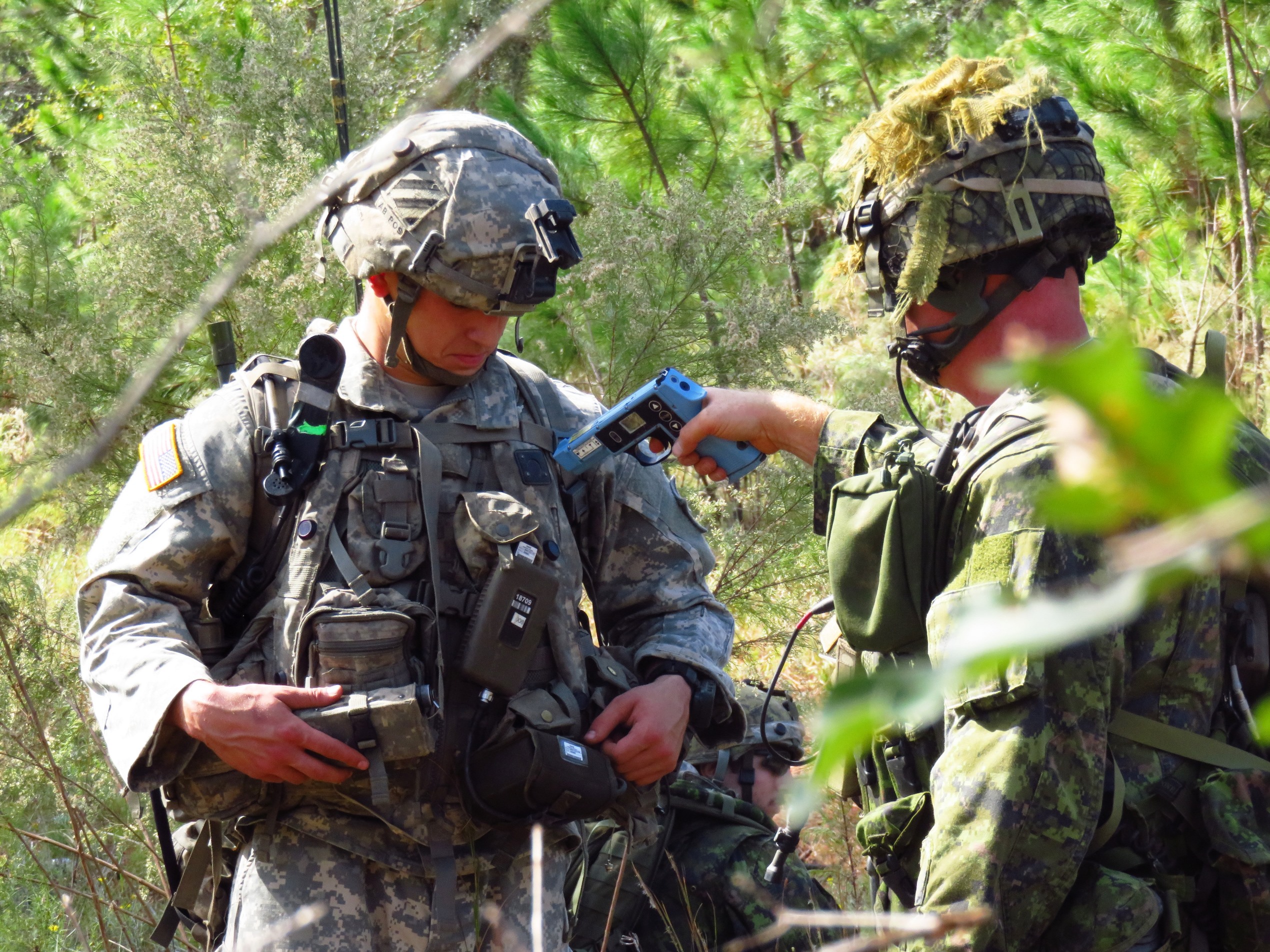 A Canadian soldier activates the multiple integrated laser engagement systems (MILES) on a U.S. Soldier during the U.S. Joint Staff-led Exercise BOLD QUEST, a demonstration and assessment that took place from October 24 to November 3, 2016 in Fort Stewart, Georgia. 