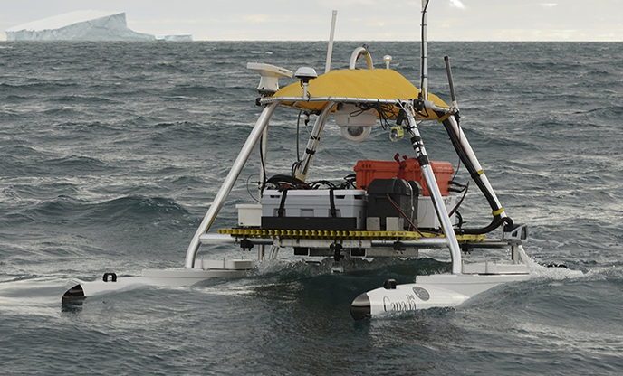 An unmanned surface vehicle uses autonomous unmanned systems to perform experiments near Barrow Strait, Devon Island, Nunavut.