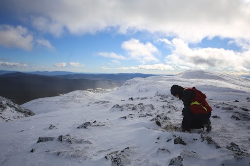 Emma Cooke doing fieldwork on a snowy mountain.