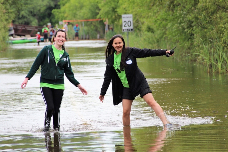 Eugenia walks with Maureen in a flooded parking lot during the “Pagayer sur la Rouge” event.