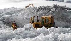 Une excavatrice enlève la neige contaminée