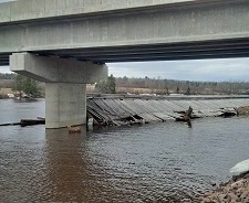 This is a picture of the 87 year old Cherryvale Covered Bridge that broke loose from its location on the Canaan River near Coles Island New Brunswick when the river flooded in mid-April. The bridge floated down the river coming to rest 2 hours later against another bridge abutment. The photo depicts the bridge partially submerged at its resting place against the new concrete bridge abutment.      