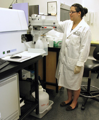 Scientist running samples through an atomic absorption spectrophotometer