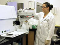 Scientist running samples through an atomic absorption spectrophotometer