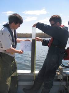 Photo: Scientifiques d'Environnement Canada prenant des échantillons de sédiments dans le fleuve Saint-Laurent.