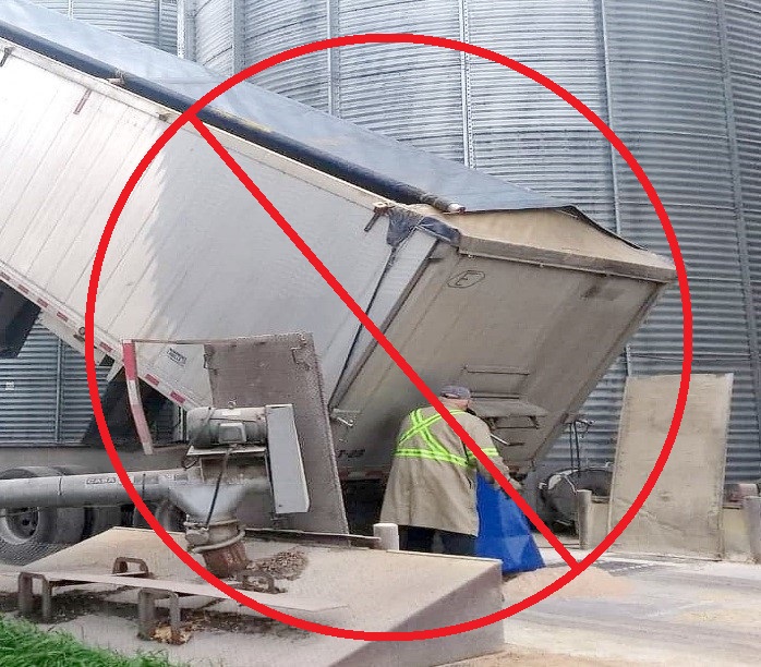 Employee positioned in the hazard zone directly behind a truck trailer 