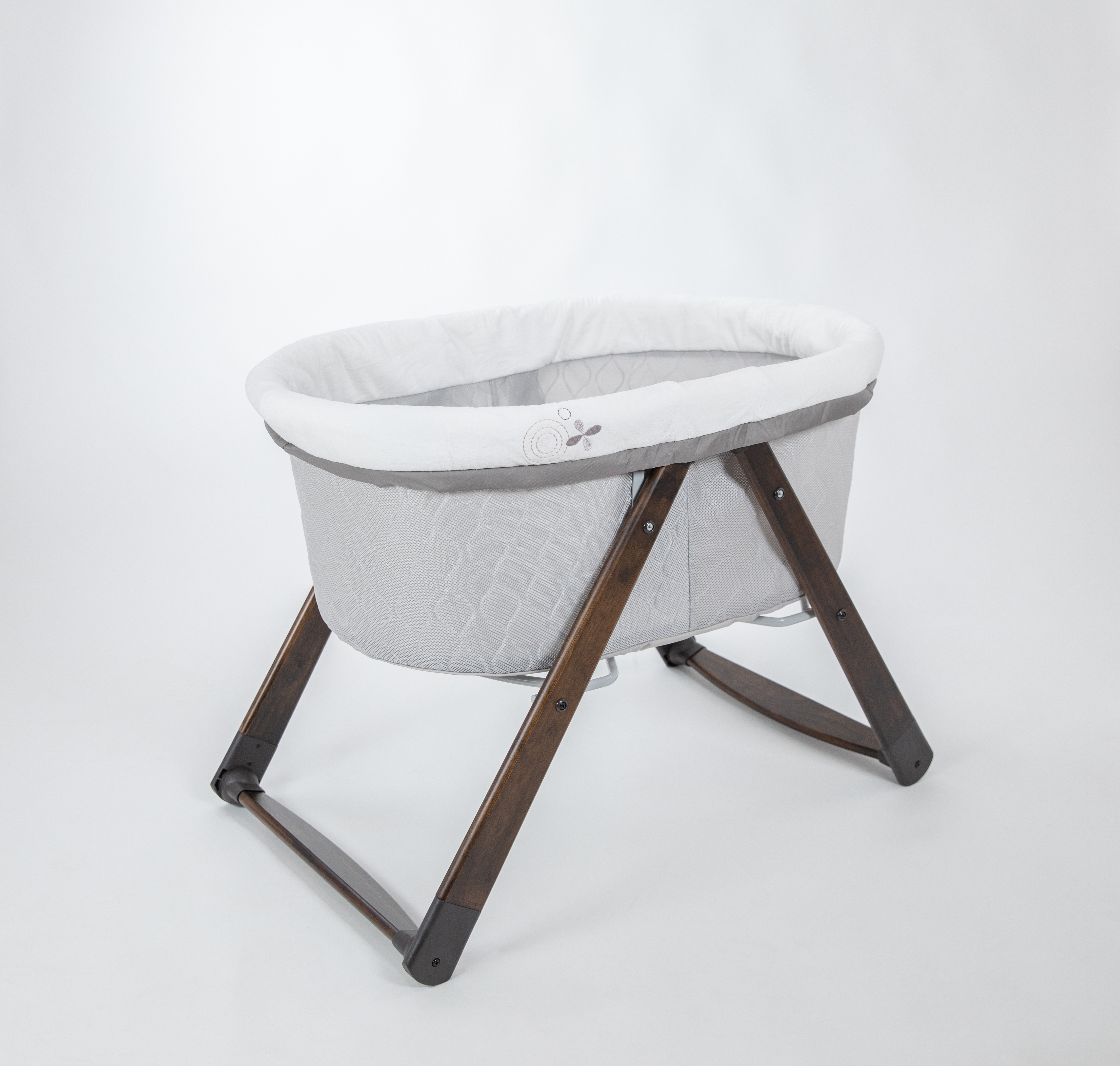 A baby bassinet with a wooden base.