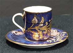 tasse et soucoupe en céramique ornées d'un motif décoratif émaillé