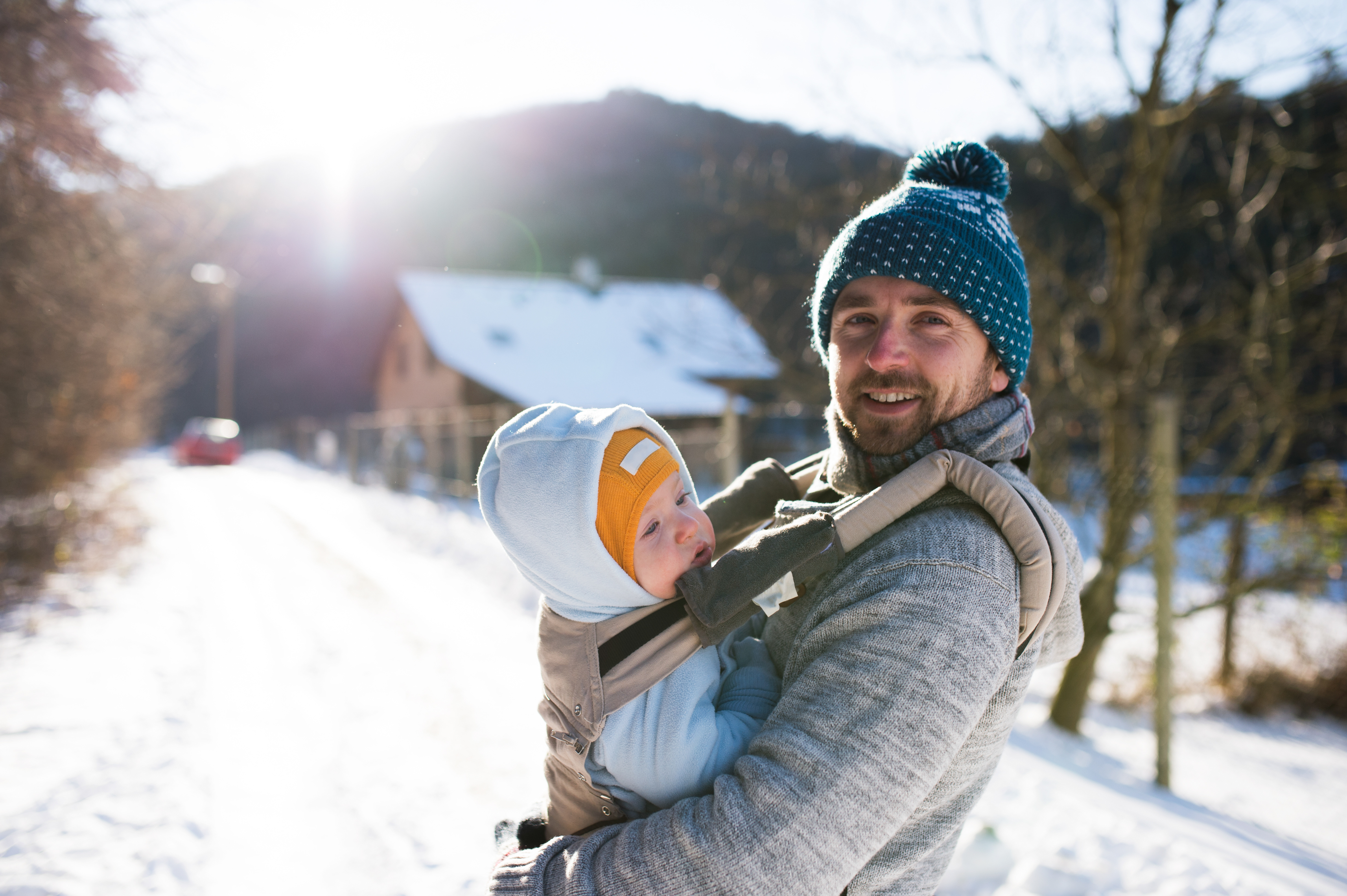A parent wears their baby in a baby carrier.