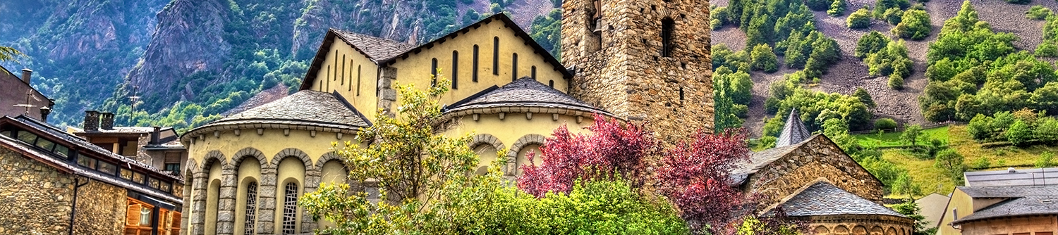 Un bâtiment se dresse devant une montagne luxuriante en Andorre.