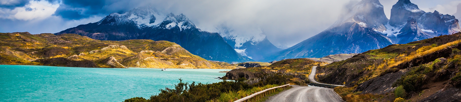 Montagnes enneigées en arrière-plan d’un lac turquoise et d’une route sinueuse au Chili