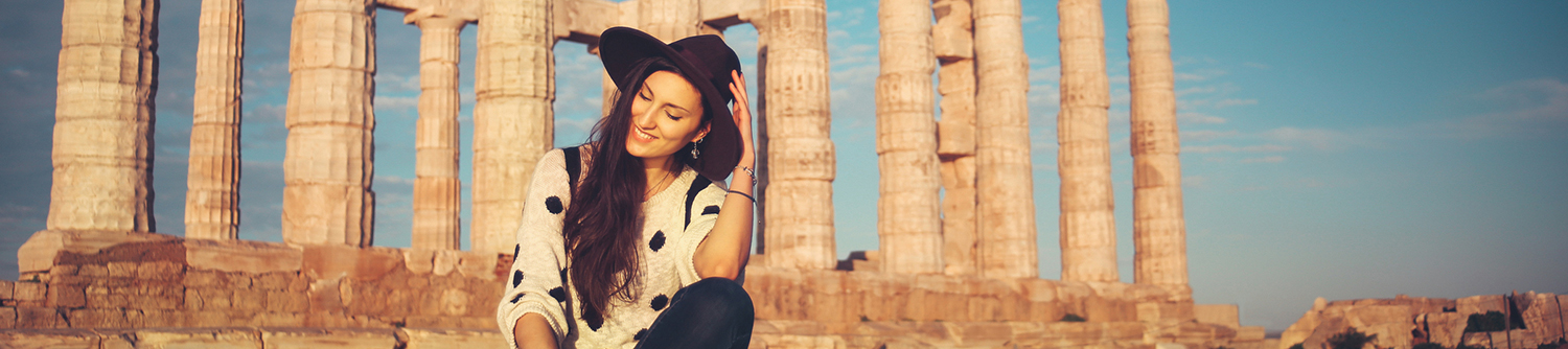 Une jeune femme se trouve devant des ruines grecques en Grèce
