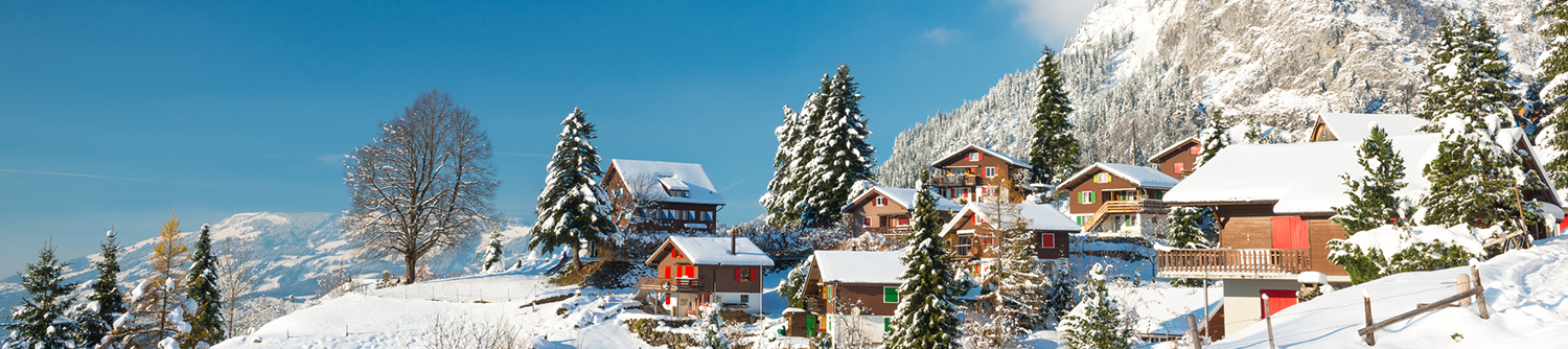 Montagnes enneigées en arrière-plan d’un village en Suisse