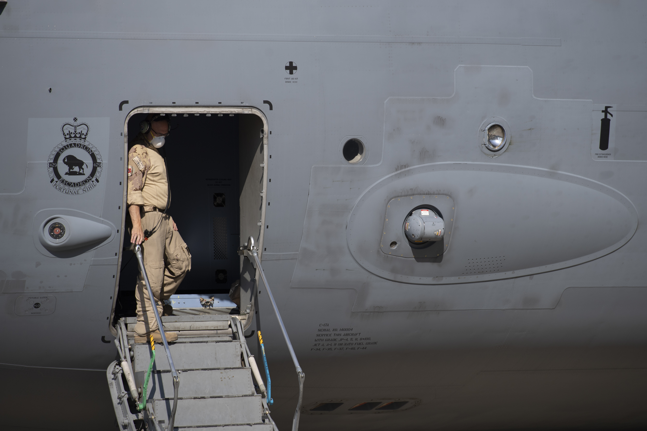 Un membre des Forces armées canadiennes se prépare à faire descendre les passagers de l’avion