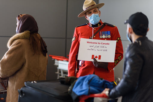 An RCMP officer welcomes Afghan refugees to Calgary on February 24, 2022.