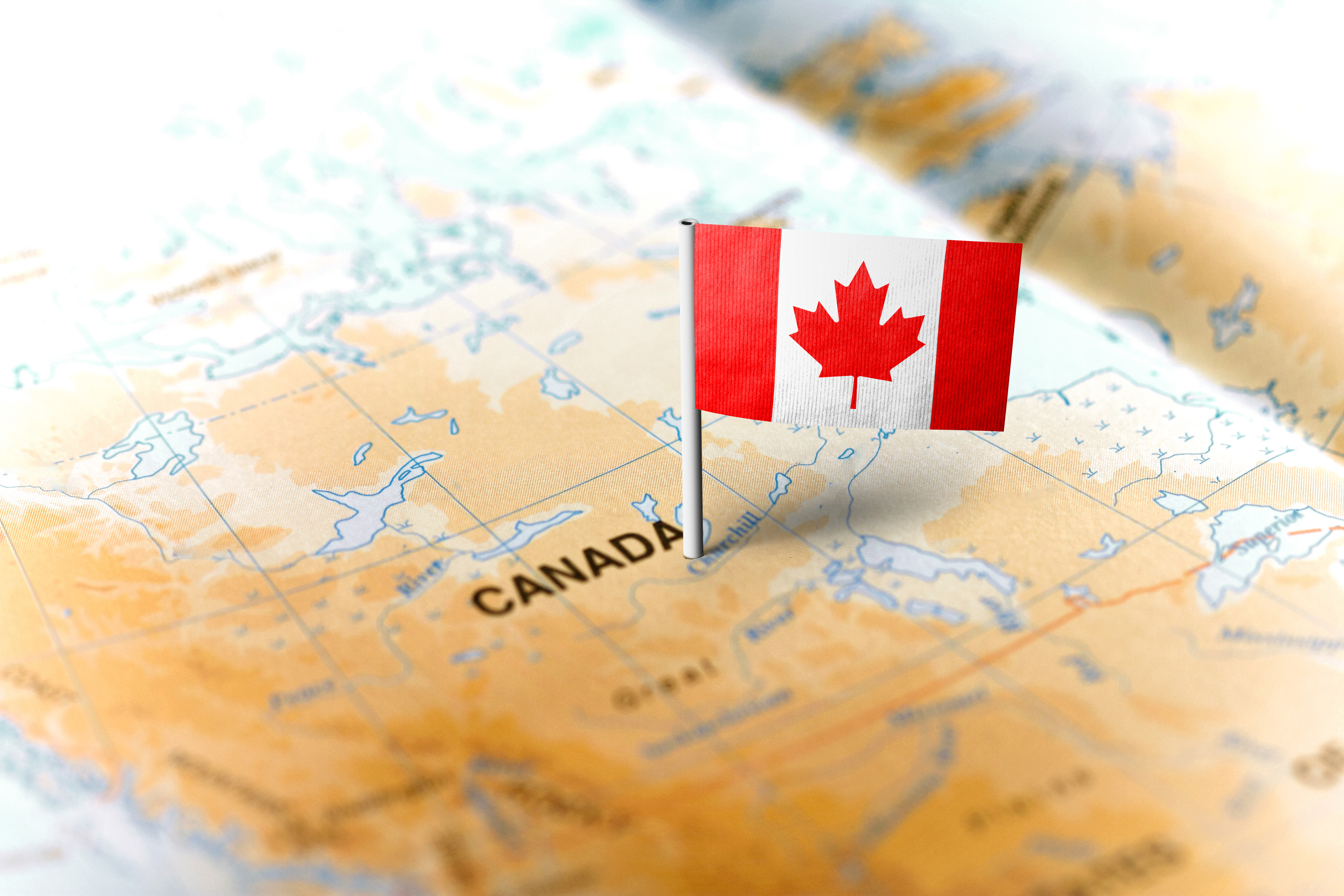 Une carte du Canada sur laquelle est épinglé un drapeau canadien.