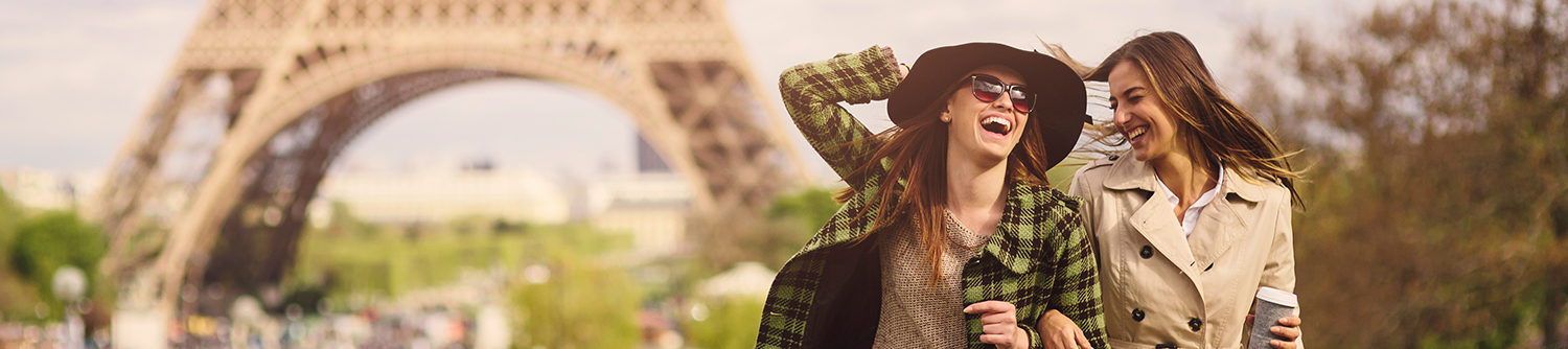 Two friends laughing near the Eiffel Tower