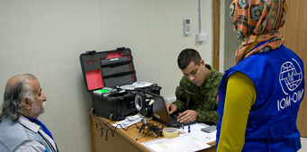 Canadian Forces member proceeds with a biometric test during the refugee screening process at the SOFEX facility.