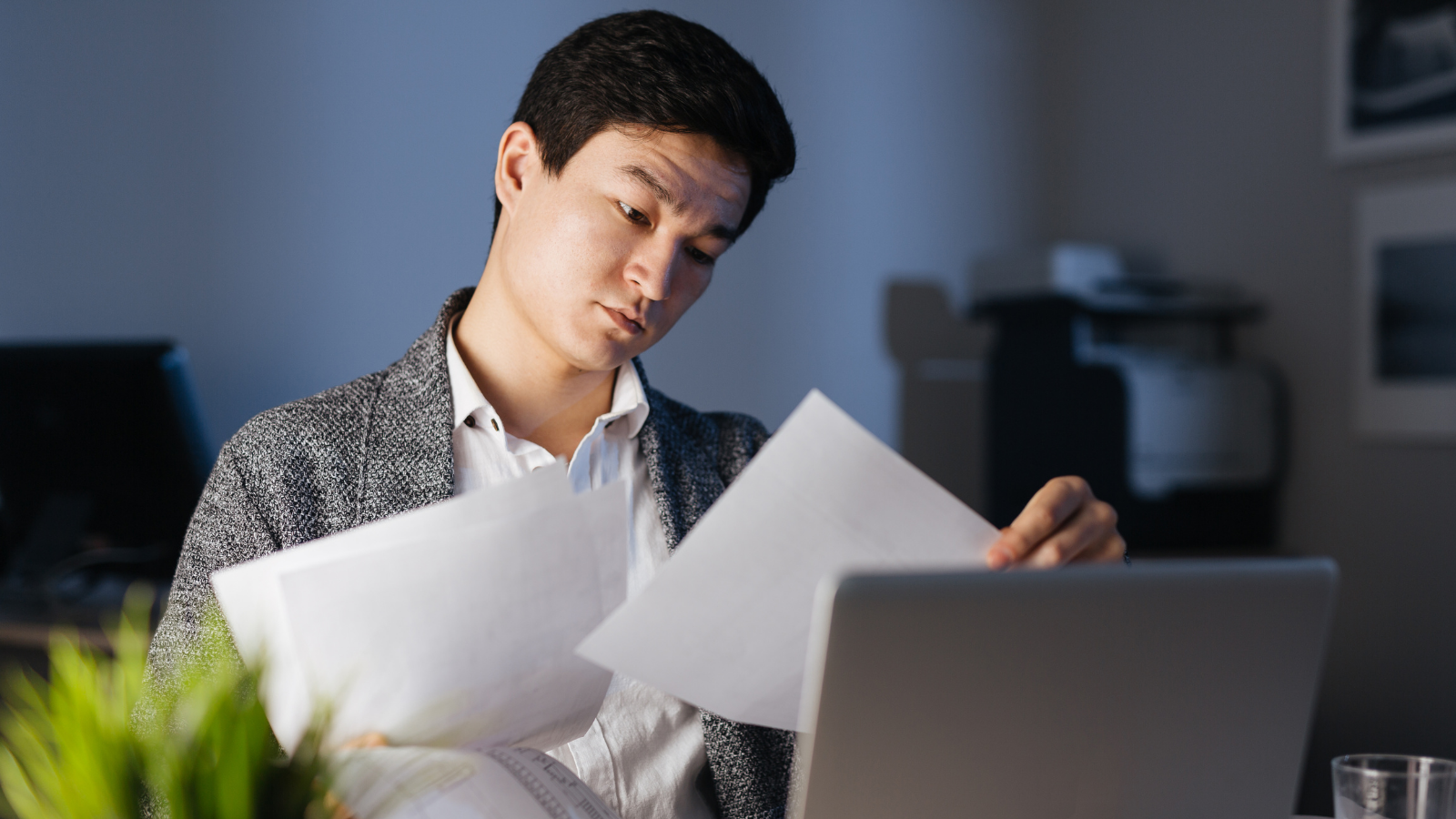 Man sitting at desk and looking at papers
