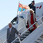 Le prince de Galles et la duchesse de Cornouailles descendant les marches hors d’un avion