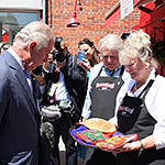 Deux commerçants locaux offrant des pâtisseries de Queues de castor au prince de Galles