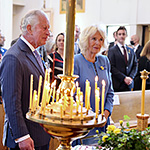 Prince of Wales and Duchess of Cornwall standing in church pew, in a cathedral