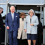 Le prince de Galles et la gouverneure générale du Canada, suivis de la duchesse de Cornouailles, sortent d’un édifice.