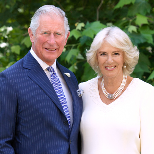 The Prince of Wales and The Duchess of Cornwall smiling and looking at the camera.