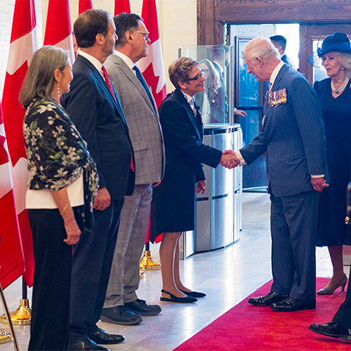 La présidente du Sénat accueille le Roi Chares III avec une poignée de main.