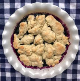Image of a blueberry cobbler in a white dish