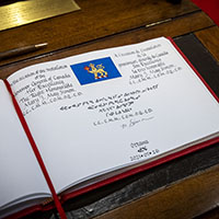 Nous voyons le drapeau du gouverneur général en haut d'une page du livre d'or : un lion doré tenant une feuille d'érable rouge sur un fond bleu. Sur la page, nous voyons aussi la signature de la gouverneure générale à l'encre noire.