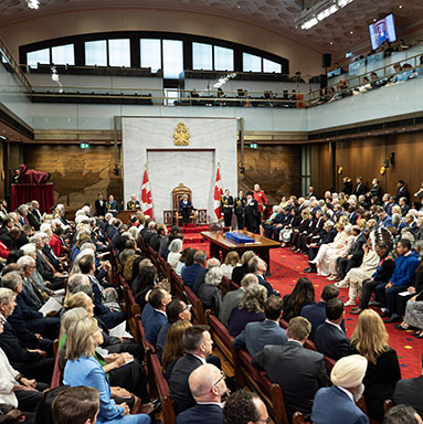 A seated audience fills the Senate Chamber.
