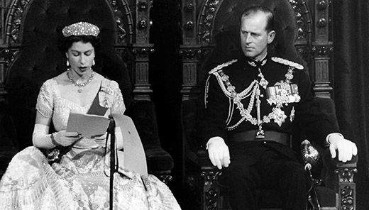 Photographie noir et blanc de la reine Elizabeth II et du duc d'Édimbourg assis sur les trônes du Sénat lors de l'ouverture du Parlement