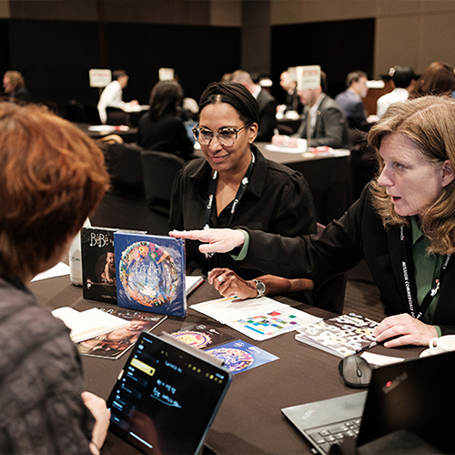 Un groupe de femmes mène des discussions d’affaires autour d’une table dans une salle de conférence.