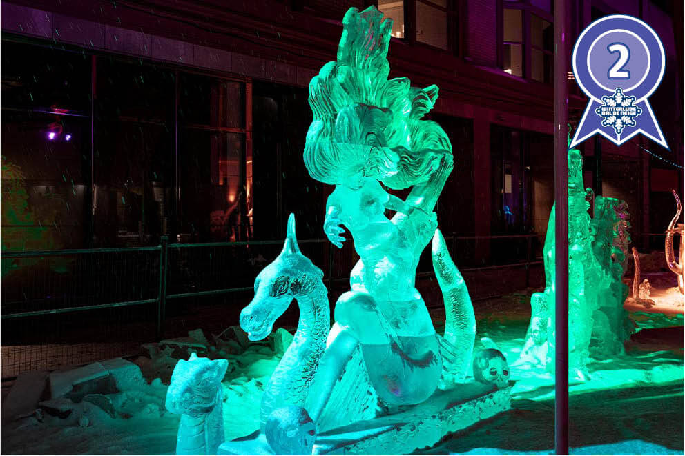 Ice sculpture of a Mermaid sitting on an icicle, with two mean sea creatures and two skulls