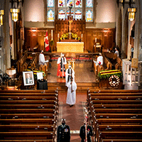 As the participants leave the altar area of the church, we see the stained glass window and the altar in the background.