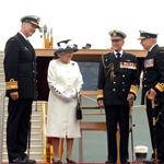 Queen Elizabeth II and the Duke of Edinburgh standing outside with two military personnel.