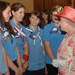 Queen Elizabeth II talking to a group of girls from the Girl Guides of Canada wearing their official uniform.