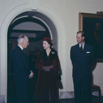 Queen Elizabeth II talking to Governor General Vincent Massey. The Duke of Edinburgh is standing next to them.