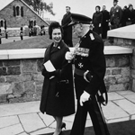 Black and white image of Queen Elizabeth II walking outside with Governor General Georges P. Vanier.