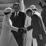 Black and white image of the Queen shaking hands with Pierre E. Trudeau. Governor General Edward Schreyer is standing behind them.