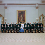 Official photo of Queen Elizabeth II seated, surrounded by dignitaries.