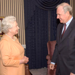 Queen Elizabeth II and Prime Minister Paul Martin standing face to face and smiling.