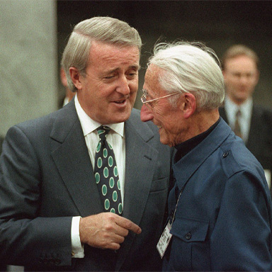 Brian Mulroney et Jacques Cousteau se tiennent côte à côte, discutent et sourient.