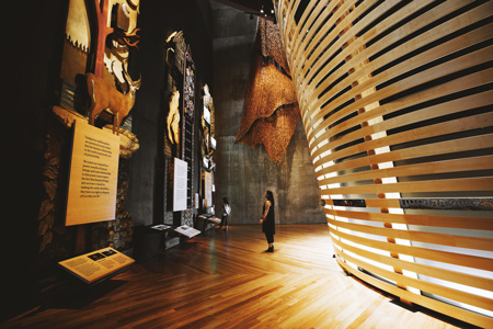 Woman standing in a hallway, looking at museum artifacts.
