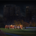 Clusters of slender bronze columns illuminated at night seen from a distance