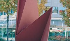 Photo of an abstract red metal sculpture depicting open and closed walls.